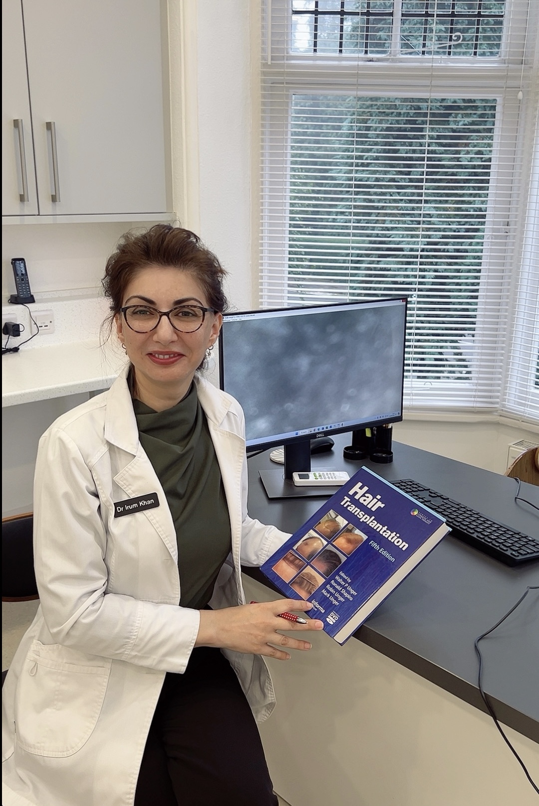 Dr. Khan with her Hair Transplantation Book in her Office